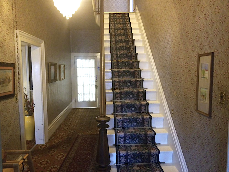 A wooden staircase leads to the second floor of the Bridgeport Inn.